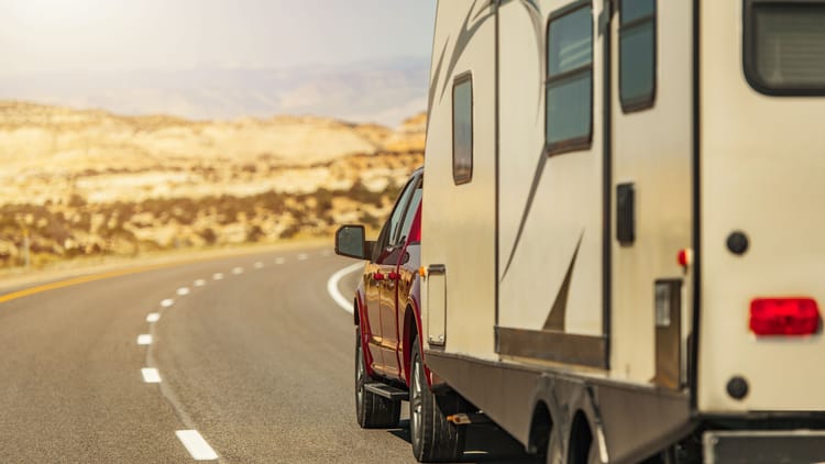 pickup truck pulling a travel trailer on a highway demonstrating how to tow a travel trailer